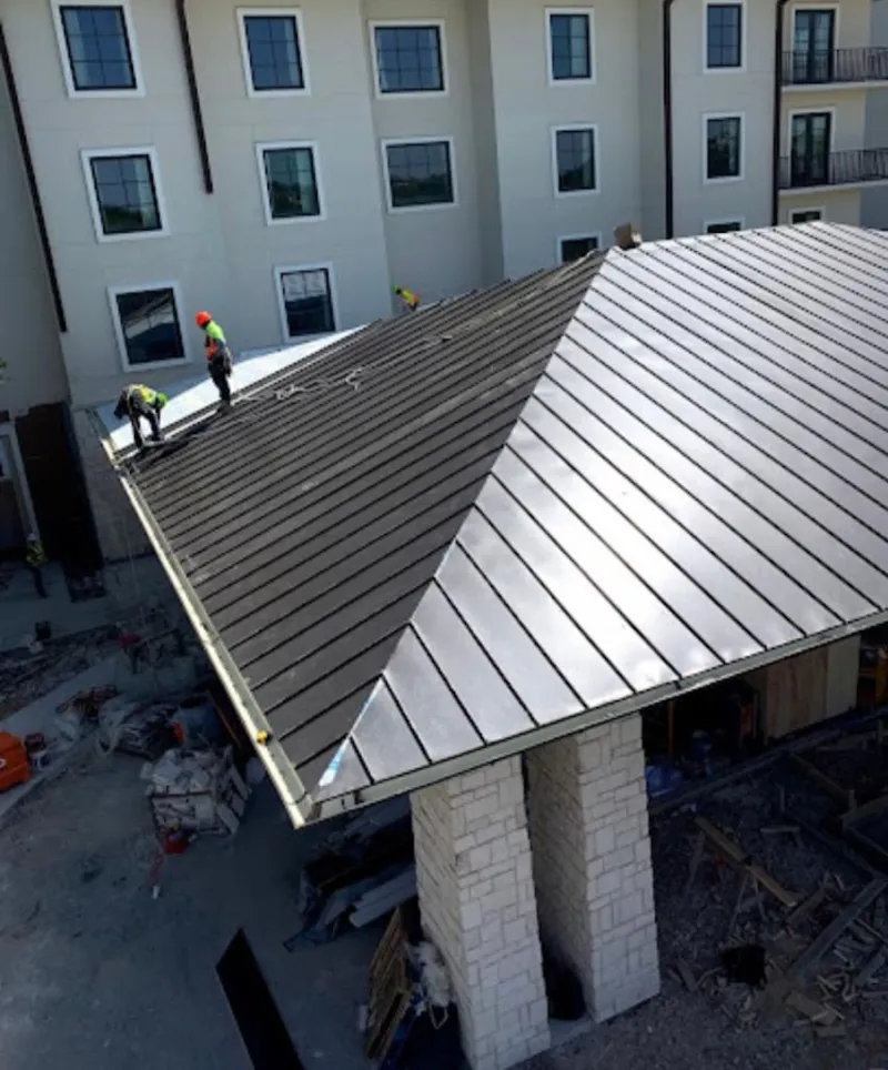 Crew installing standing seam metal roof panels on a commercial project in Maple Heights